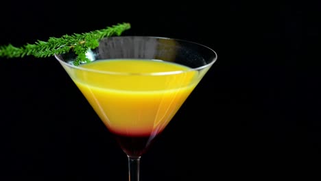 close up shot of beautiful served orange cocktail in studio with black background