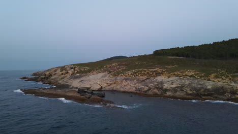 inzoomen op golven die breken op rotsachtige kustlijn