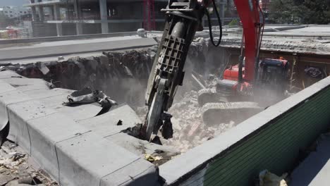 close-up shot of a digger cutting through the remaining concrete roofing creating dust