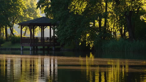gazebo by a lake at sunrise/sunset