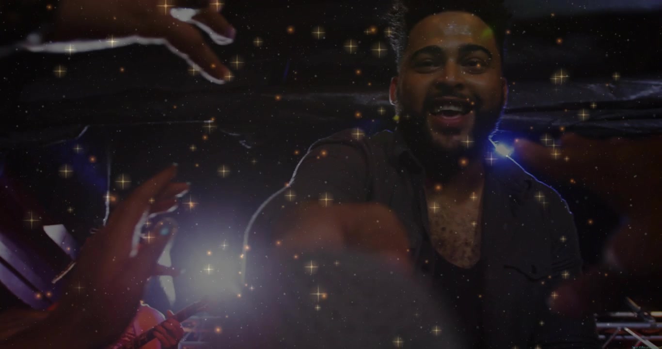 Male singer reaching gray sphere in concert, crowd reaching first, sparkles amplifying interaction