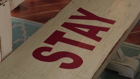 the word stay on a distressed bench at a beach house