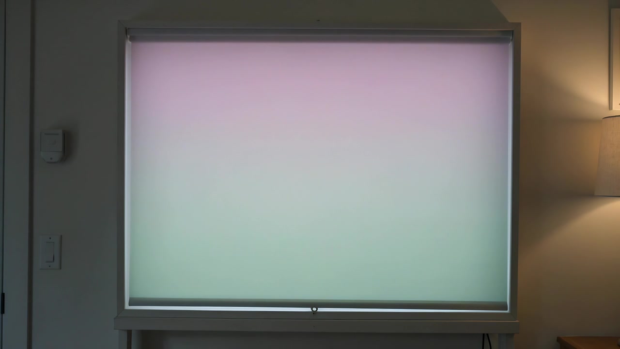 Mostrando una tenda a rullo con la barra inferiore che cambia lentamente colore mentre la luce del giorno cambia a casa, lampada accesa.
