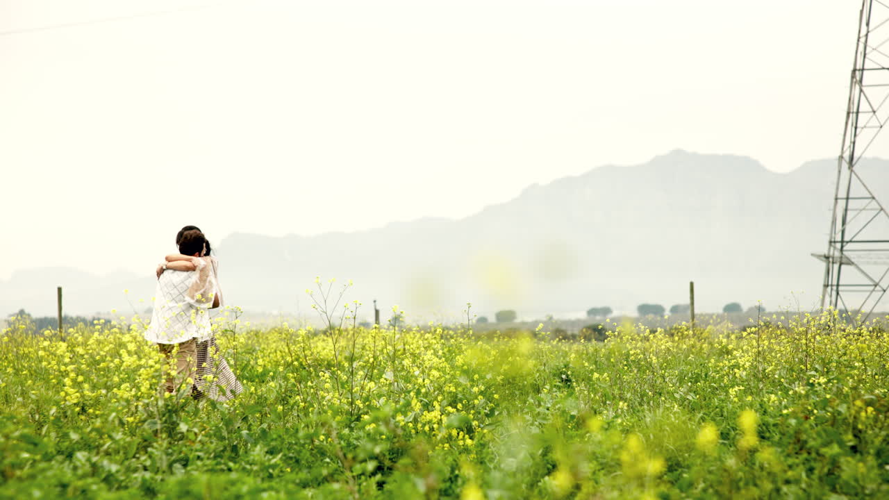 Couple in a Field of Flowers with Mountain Backdrop