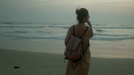 woman with a backpack looking at the sea