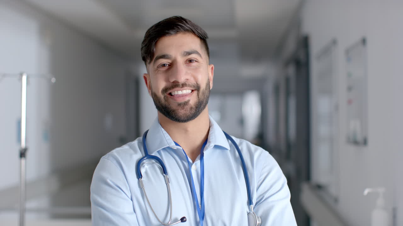 Jovem médico asiático em traje médico posa confiante em um hospital.