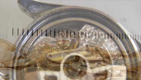procesamiento de datos financieros en primer plano de un reloj y monedas de oro de yenes contra un fondo gris