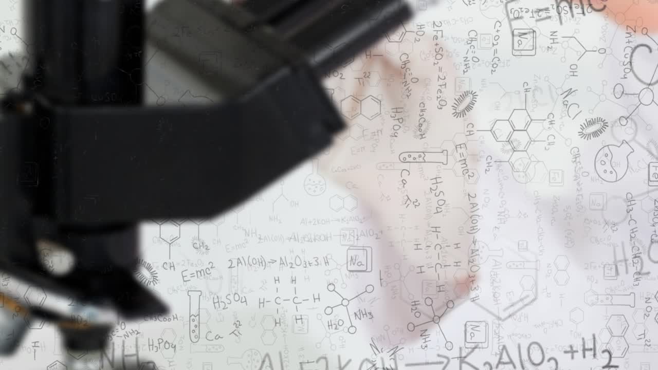 Researcher's hand sweeping across clear board beside microscope, tracing chemical reaction paths