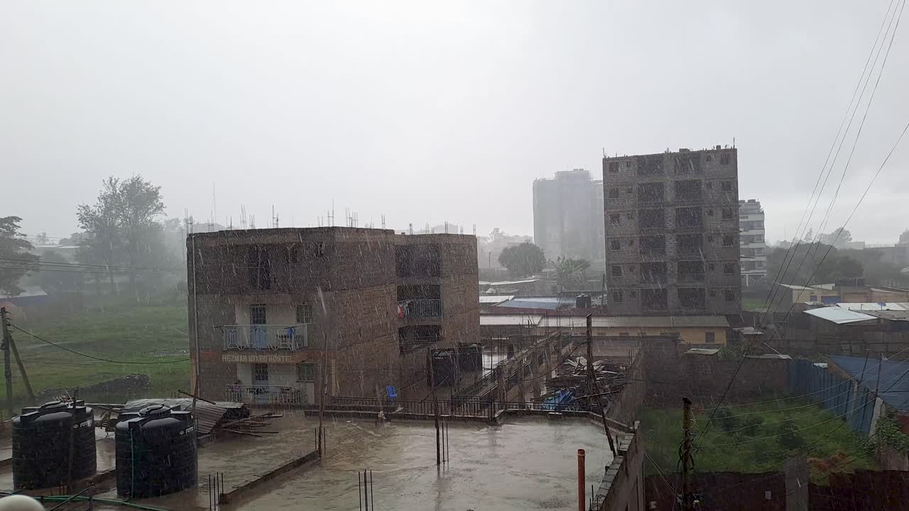 Fuertes lluvias sobre edificios residenciales y tejados de Nairobi durante un día lluvioso y húmedo en el paisaje urbano de Kenia.