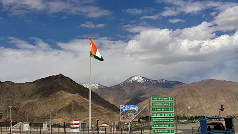 flag waving and moving in slow motion in the leh ladakh city with vehicles moving. patriotism