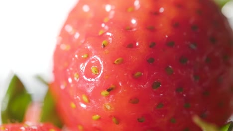 Extreme-Nahaufnahme-Von-Wassertropfen,-Die-Auf-Eine-Frische-Erdbeere-Spritzen,-Zeitlupenaufnahme