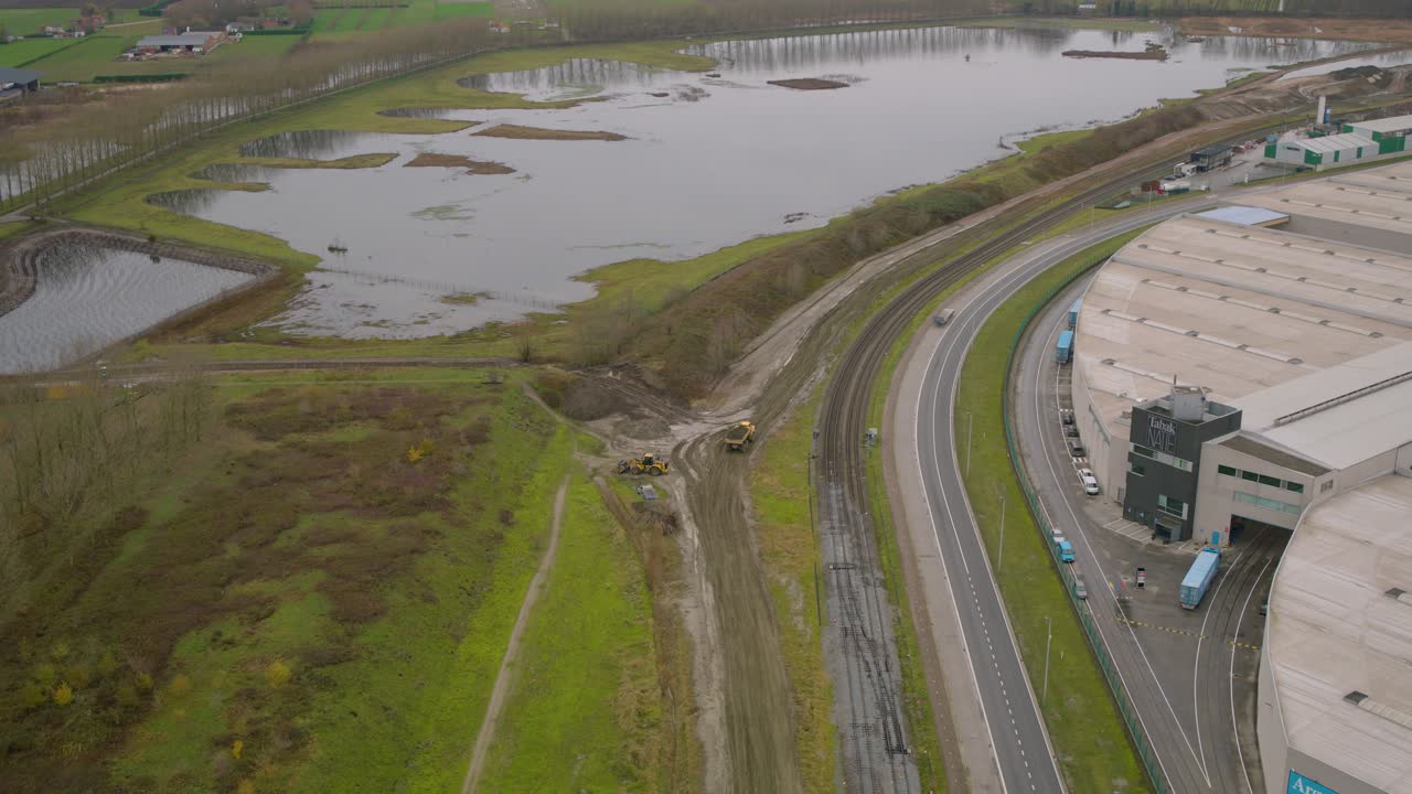 Heavy dump truck transporting soil on dirt road, aerial view