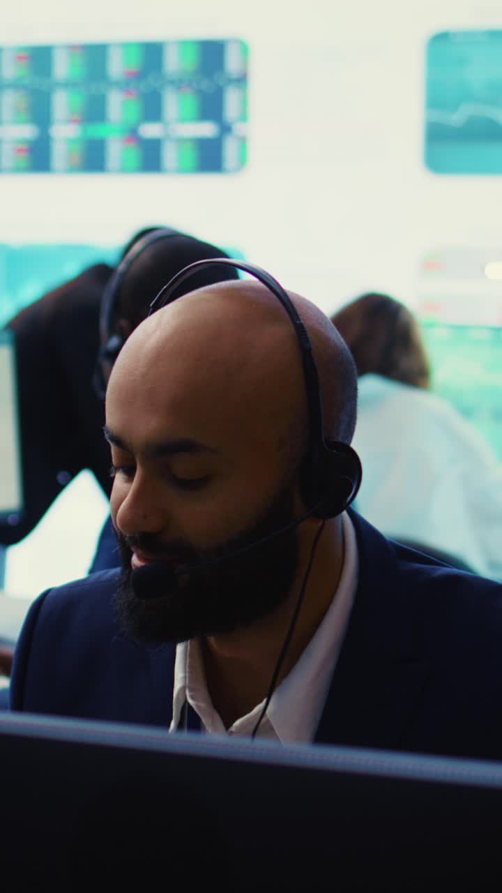 Forretningsmann med headset overvåker data i moderne kontor