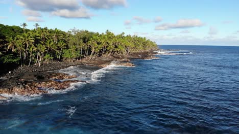 slow moving flight parallel to the coast over the ocean on a sunny day on south east hawaii island