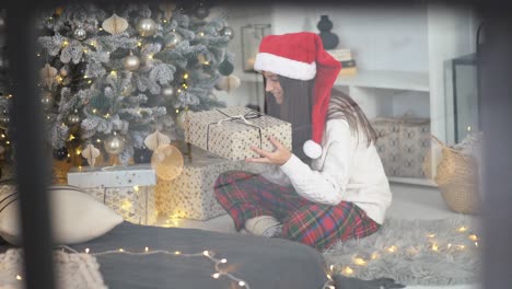 mujer abriendo un regalo de navidad