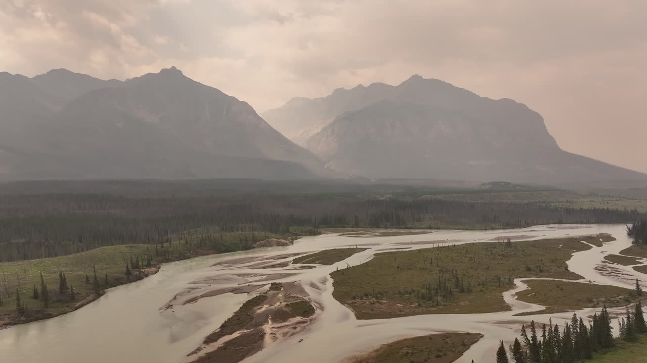 el humo de los incendios forestales oscurece las montañas rocosas mientras el avión no tripulado vuela a lo largo del norte del río saskatchewan en alberta, canadá