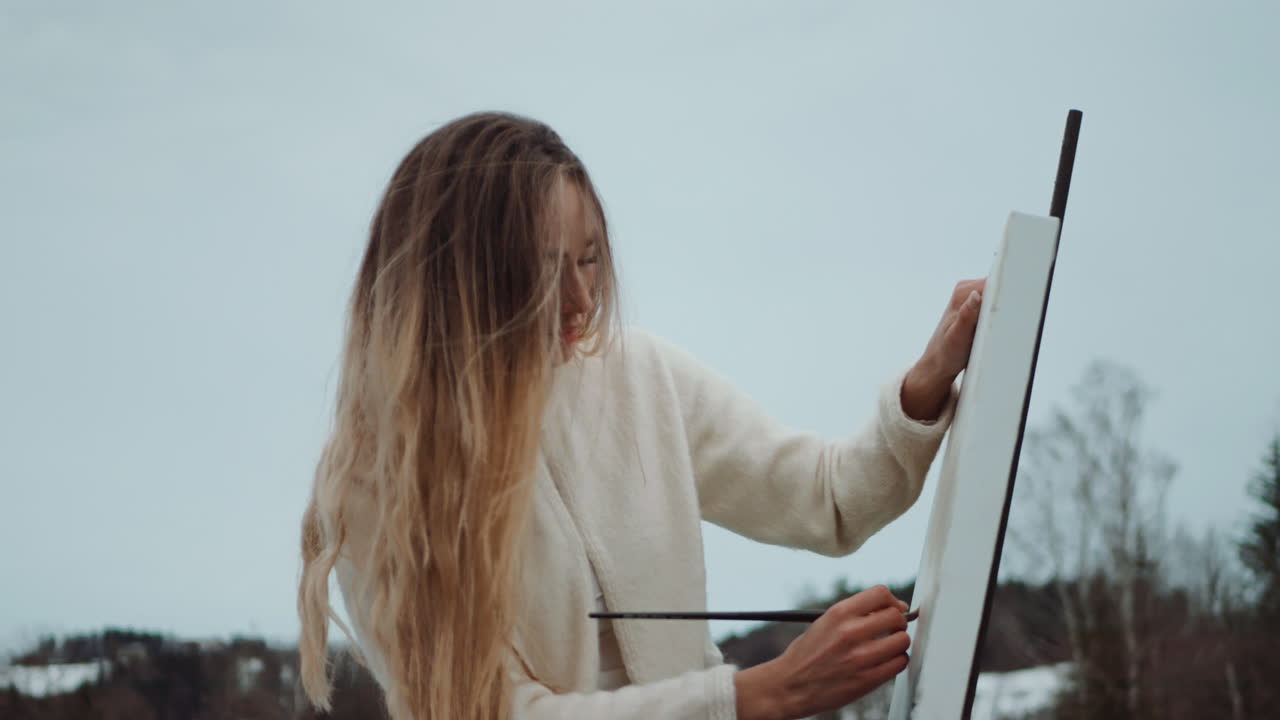 Woman painting outdoors in winter