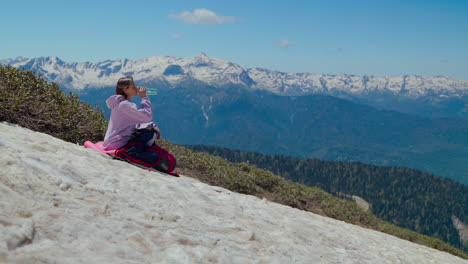 woman hiking and drinking water in the mountains
