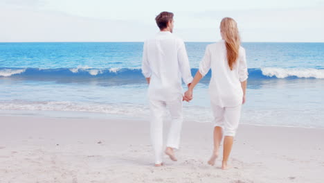 happy couple walking on the beach