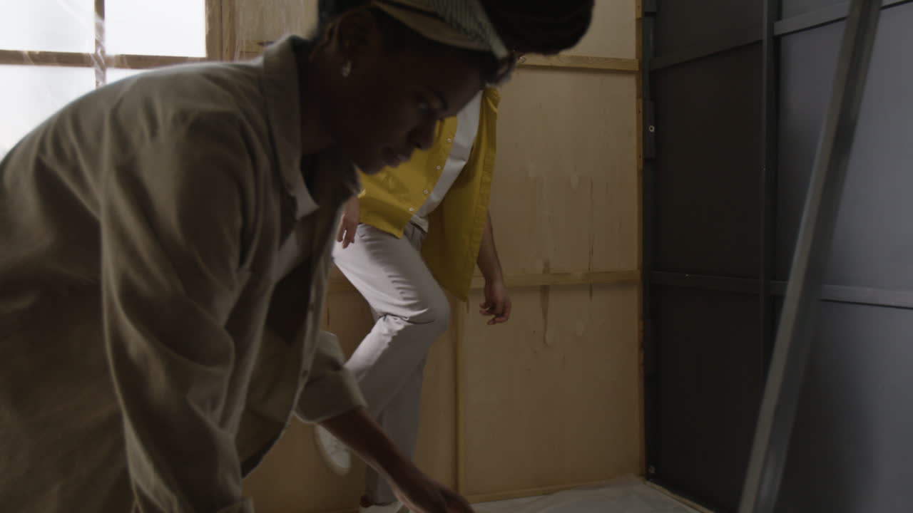 People installing plastic sheeting indoors