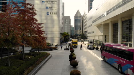 aerial shot of a man walking on the street between two tall buldings in korea, sun, landscape