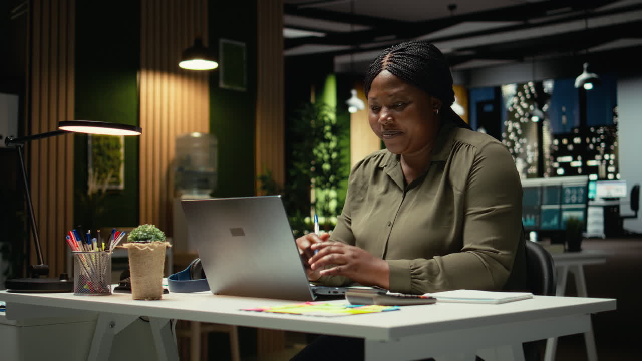 African american woman in office chatting on video call and smiling
