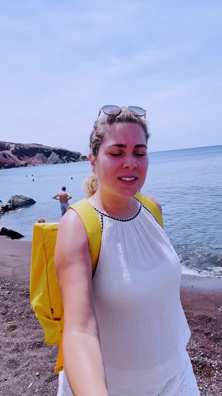 Influencer vlogger sin ferie ved den røde strand på Santorini, Grækenland