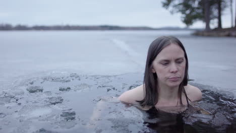 a woman in her 40s finishes her daily ice bathe and exits the lakewater