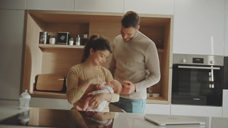 happy family with a newborn baby in the kitchen
