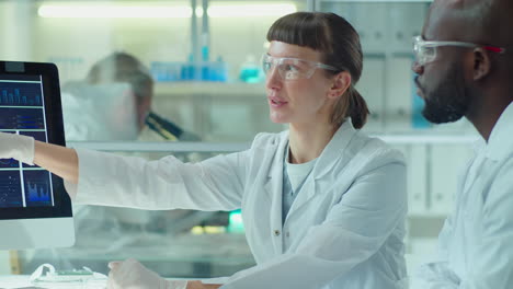 multiethnic scientists discussing micrograph on computer