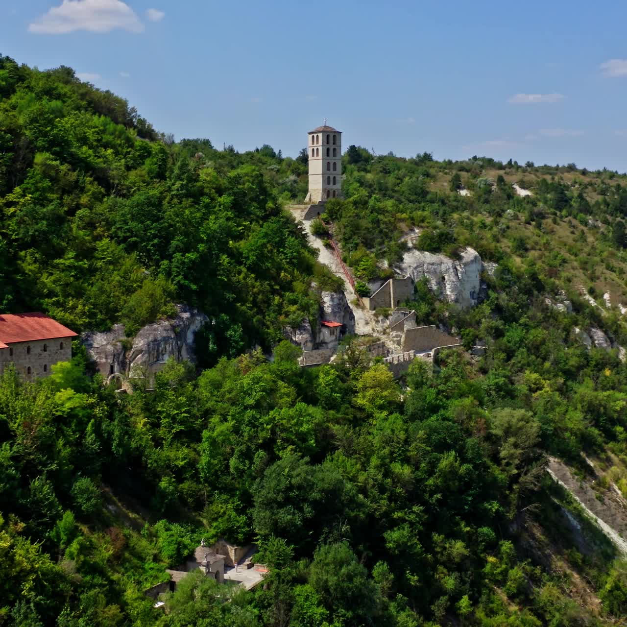Historical architecture located on hills. Panoramic view of buildings in the mountains with green areas in summer. Aerial view.
