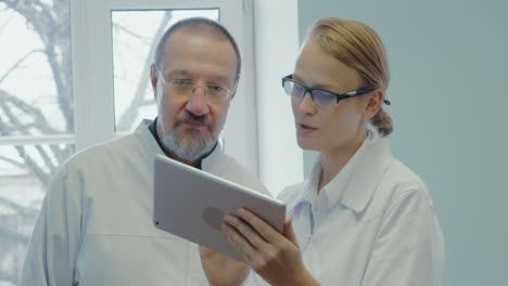 dos médicos que tienen una conversación profesional usando el panel táctil