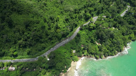 Top-shot-of-vehicles-driving-on-the-highway-along-Khao-Lak-coastline,-Phuket,-Thailand