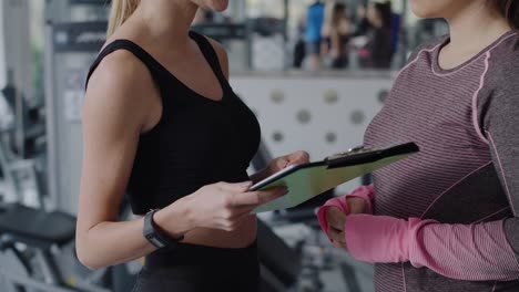 Tilt-up-view-of-fitness-instructor-and-woman-having-a-chat