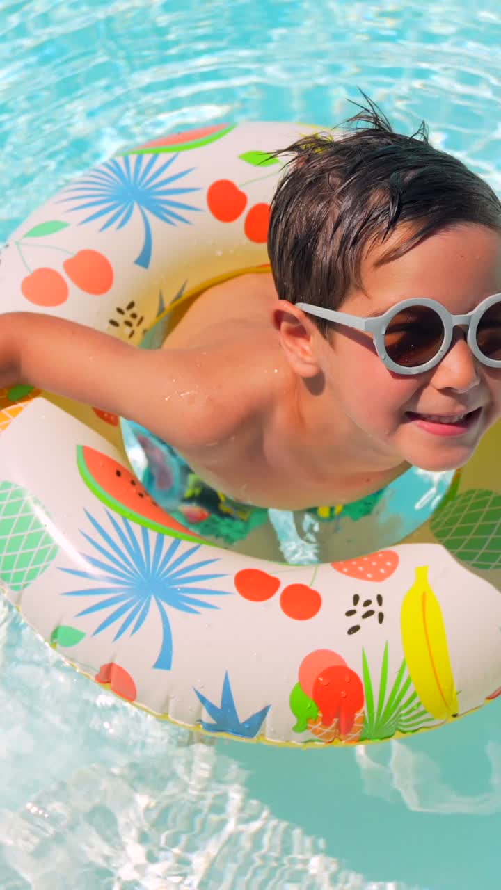 Boy in pool with sunglasses and inflatable float