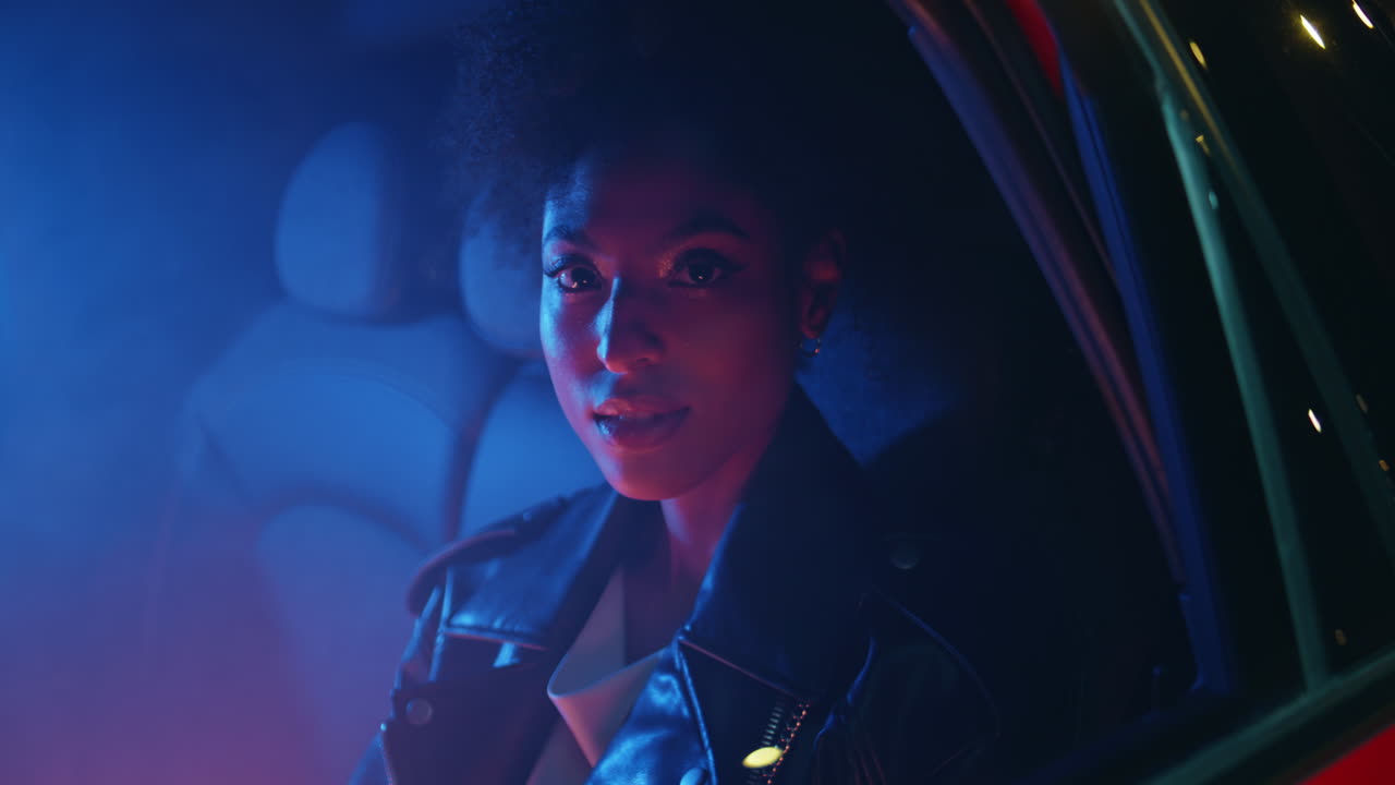 Stylish lady sitting backseat car illuminated neon light closeup. woman