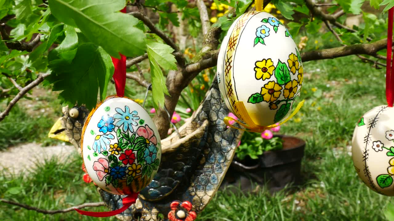 Ostereier hängen am Zweig im Garten. Schwenk.