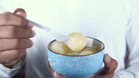 primer plano de un hombre comiendo dulces en un cuenco
