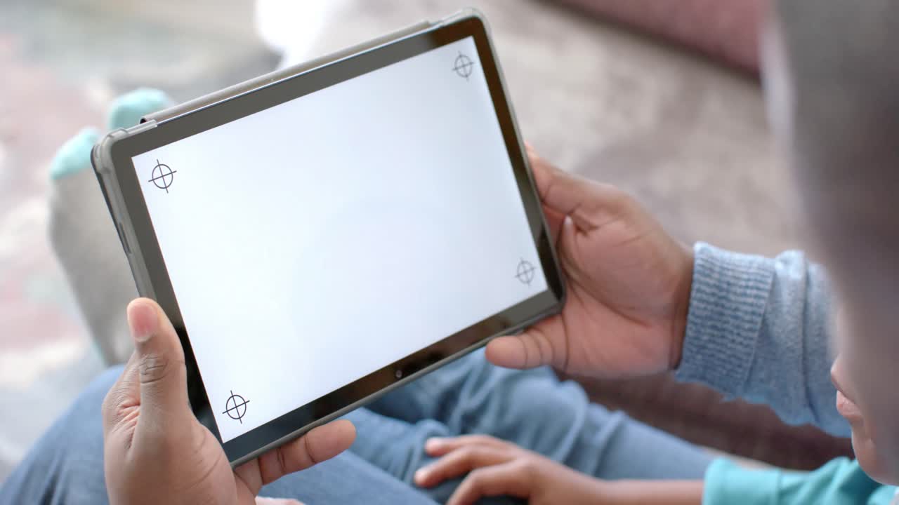 padre e hijo afroamericanos felices usando una tableta en casa con espacio de copia en la pantalla, en cámara lenta