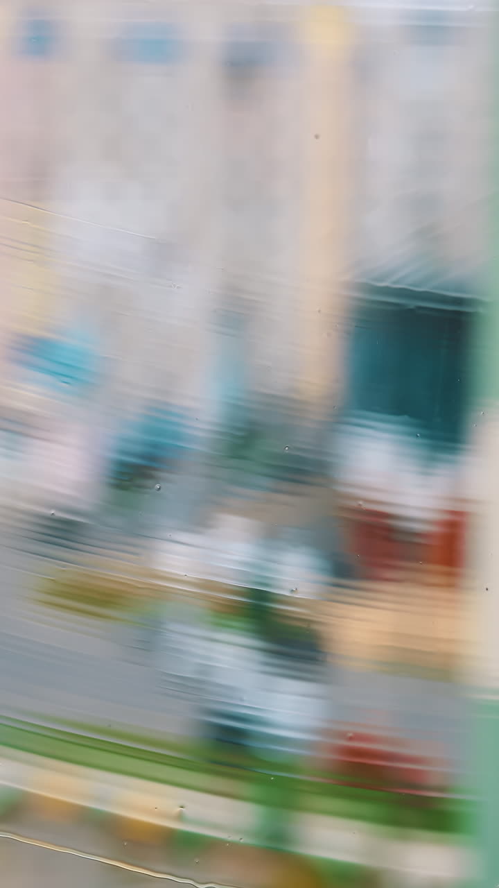 Window cleaning brush washing. Cleaning window with water and special liquid in the city flat. Close-up. Vertical video