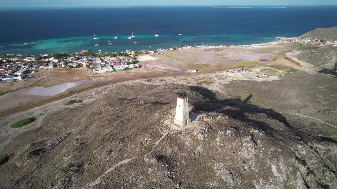 Ilha Gran Roque com um farol e águas turquesa vibrantes, vista aérea
