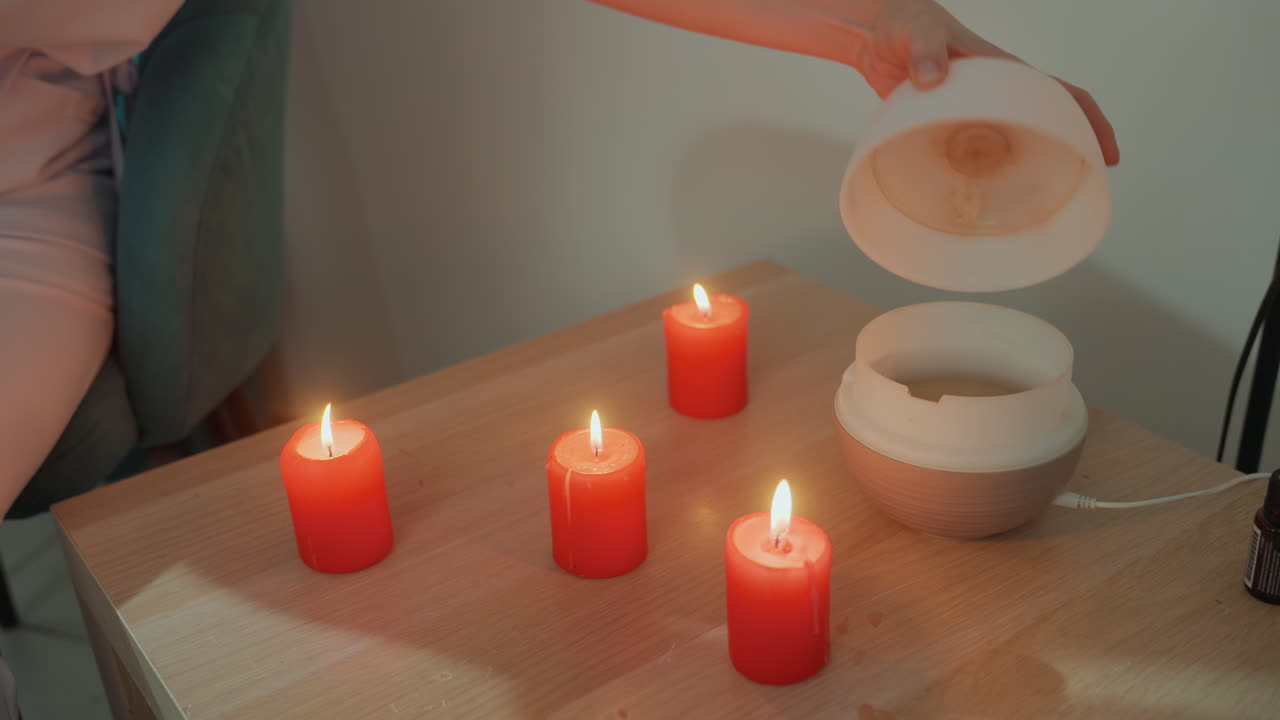 Kafkas kadın rahatlatıcı bir aroma seansı kuruyor. Ahşap yüzeye sakinleştirici aromaterapi için nazikçe su döküyor. Kadının nazik el hareketi, rahat ev spası ortamında yatıştırıcı bir atmosfer yaratıyor.
