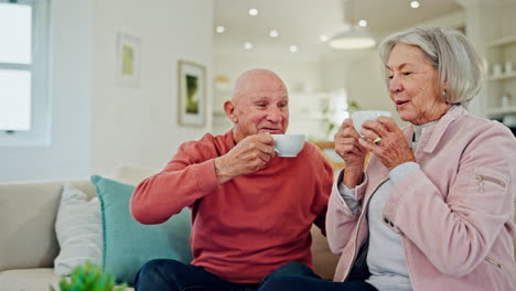 Älteres-Paar,-Kaffee-Und-Gespräch-Auf-Dem-Sofa-Für-Ein-Lächeln