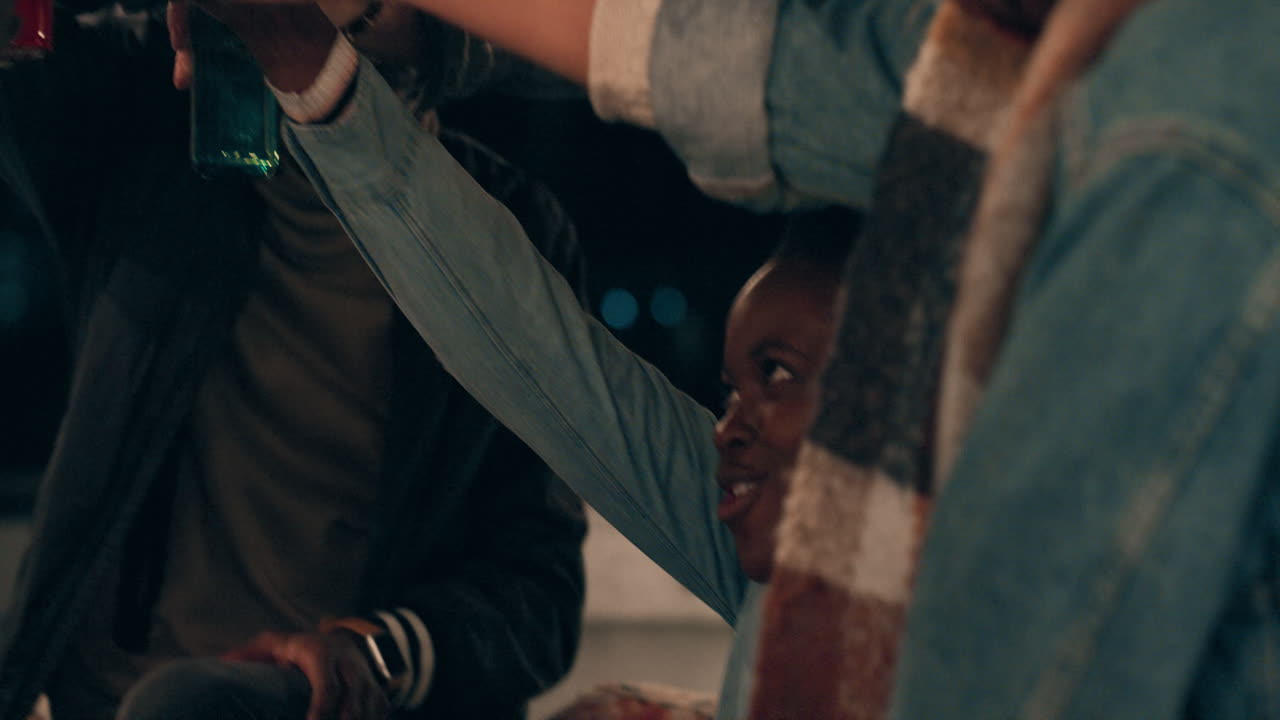 grupo feliz de amigos a desfrutar de uma festa no telhado a beber cerveja a fazer brindes a divertir-se a reunir-se socialmente a celebrar o fim de semana da amizade à noite