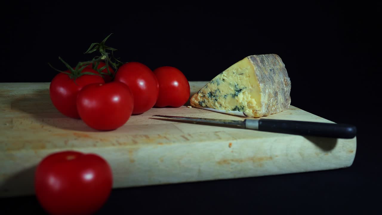 Pomodori e formaggio su un tagliere con coltello - scorrimento a sinistra