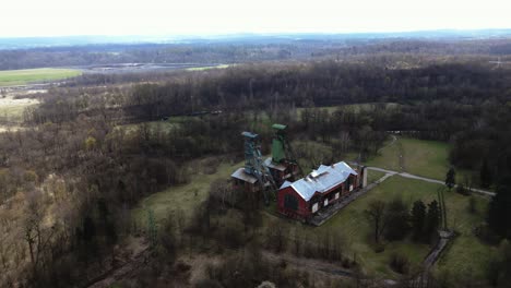 Aerial-drone-footage-circles-around-the-two-towering-structures-of-the-former-Gabriela-coal-mine,-revealing-the-surrounding-area