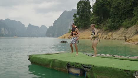 people jumping and swimming in a scenic lake
