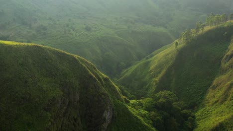 Aerial-drone-flyover-shot-of-the-green-valleys-and-cliffs-in-the-Karo-Regency-near-Sipiso-Piso-in-North-Sumatra,-Indonesia