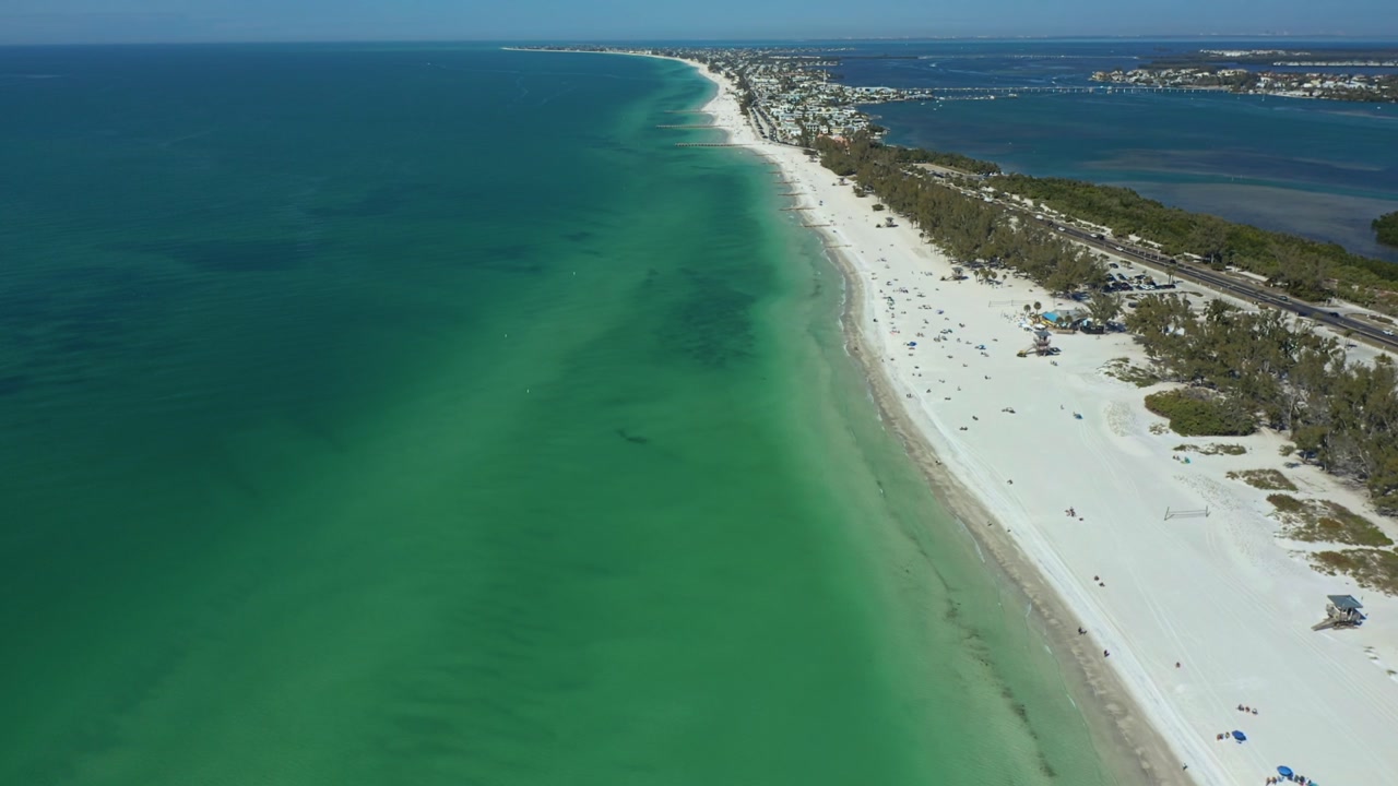 Sweeping aerial view of Bradenton Beach showcasing turquoise waters and pristine white sands. Ideal for tourism and coastal lifestyle visuals.