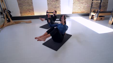 women doing exercises with pilates ring in studio